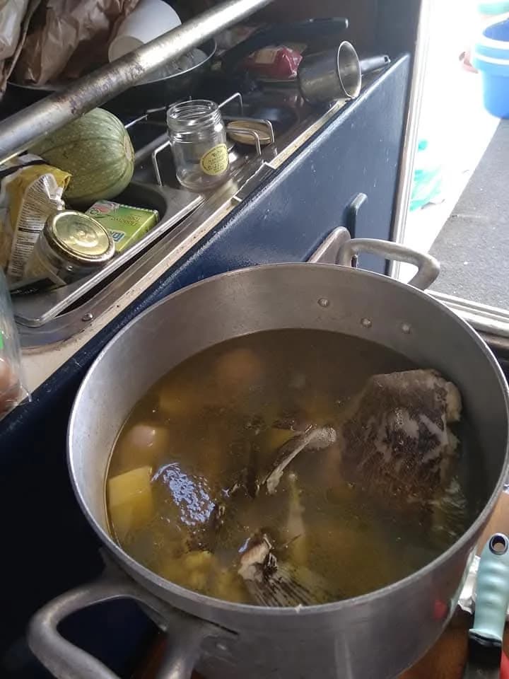 Fresh fish soup cooking in a pot aboard
