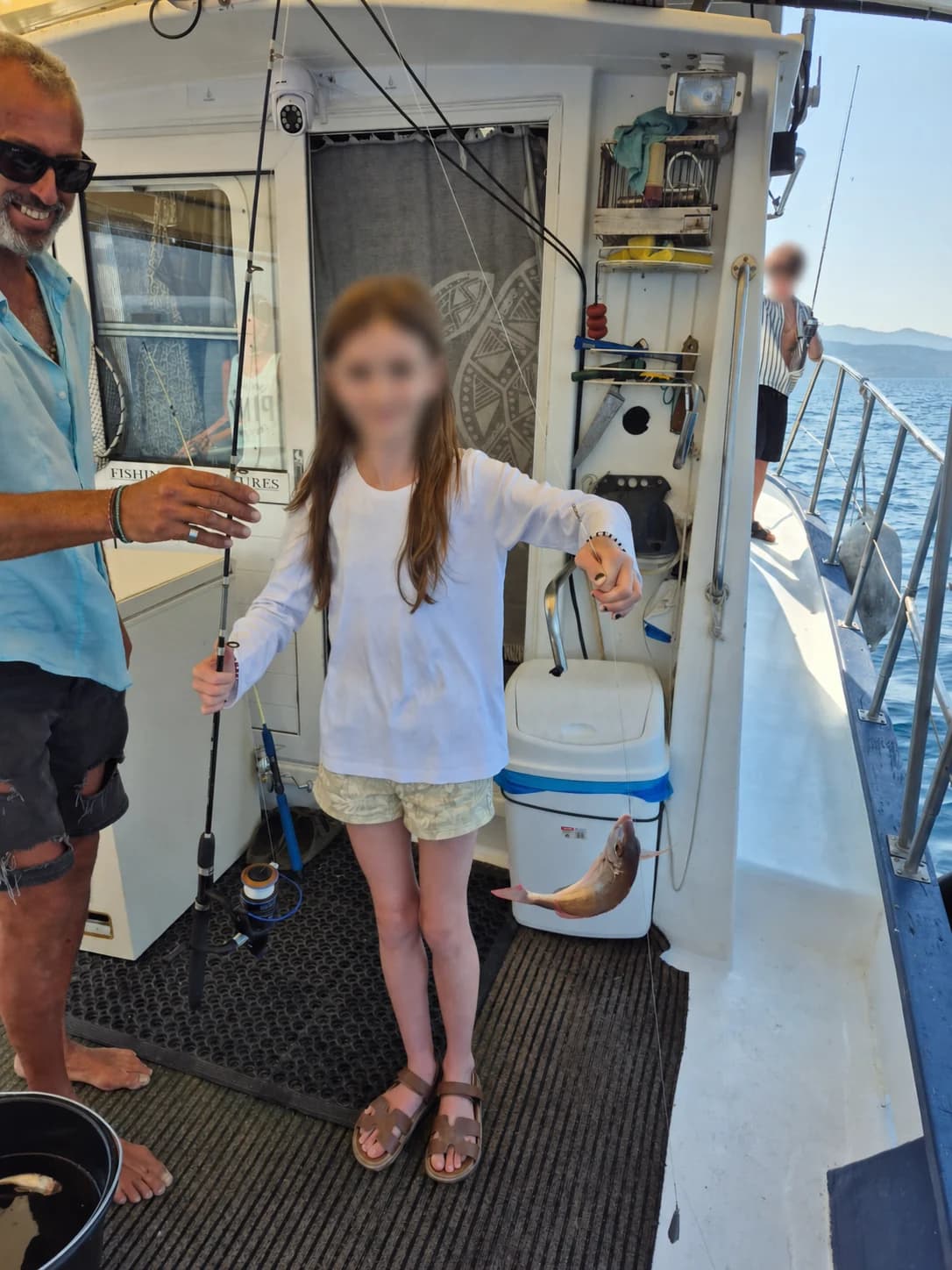 A young angler fishing aboard with the face privacy-protected
